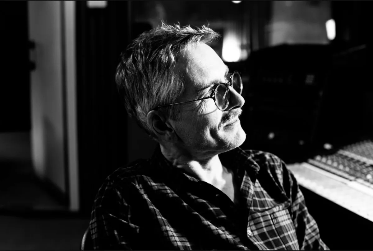 Arne Schumann in profile at the console, glasses on, black and white